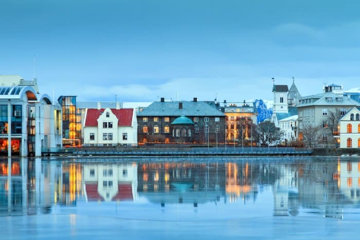 Beautiful reflection of the parliament house Althing of Reykjavik in lake Tjornin at the blue hour in winter