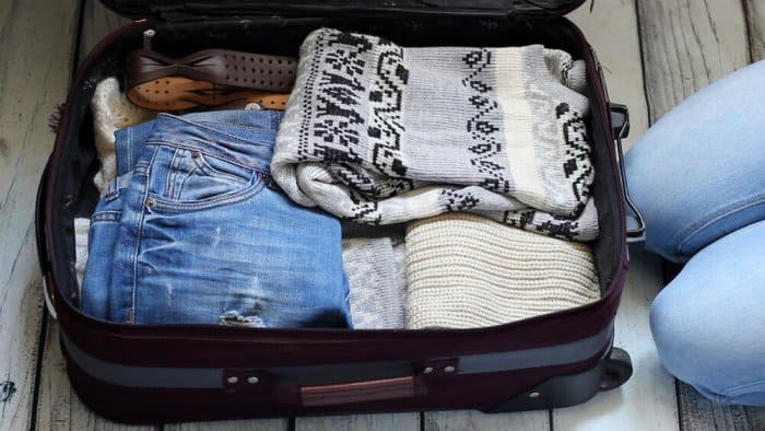 Open suitcase with warm items on the Iceland summer packing list
