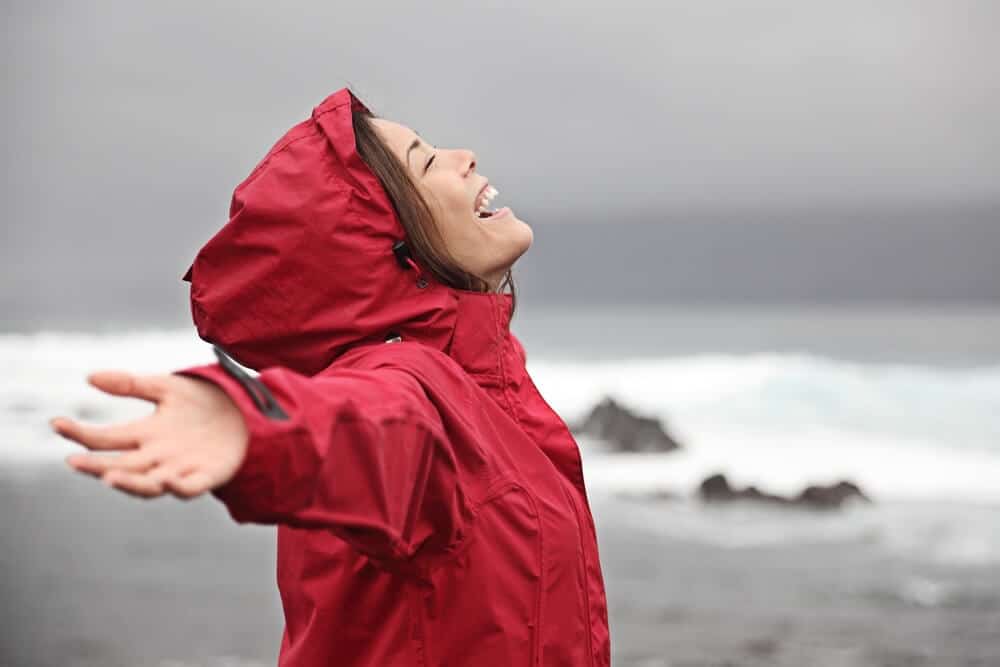 Woman wearing red rain jacket during rainy September weather in Iceland