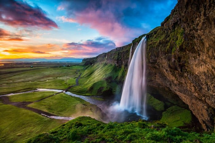 Seljalandsfoss at sunset with colored sky is a main stop on Iceland's Ring Road