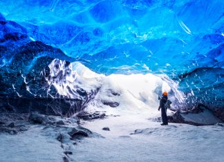 tourist visiting an Ice cave inside of a glacier in Iceland