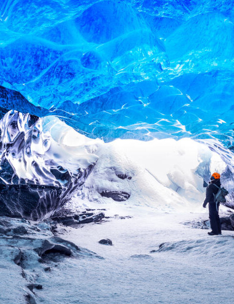 tourist visiting an Ice cave inside of a glacier in Iceland